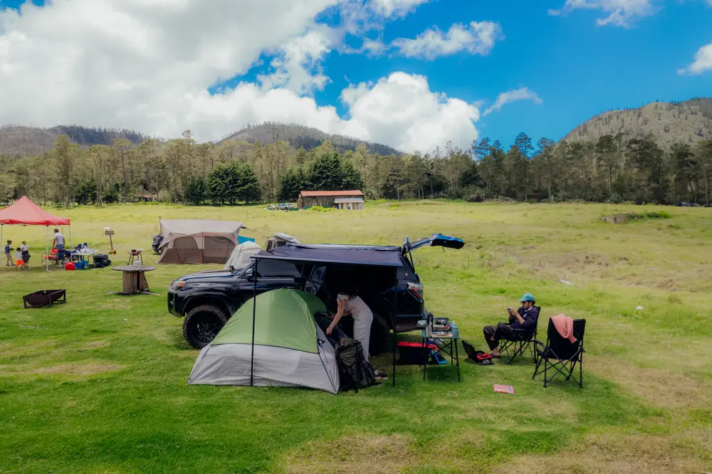 Carpa y vehículo frente a la montaña