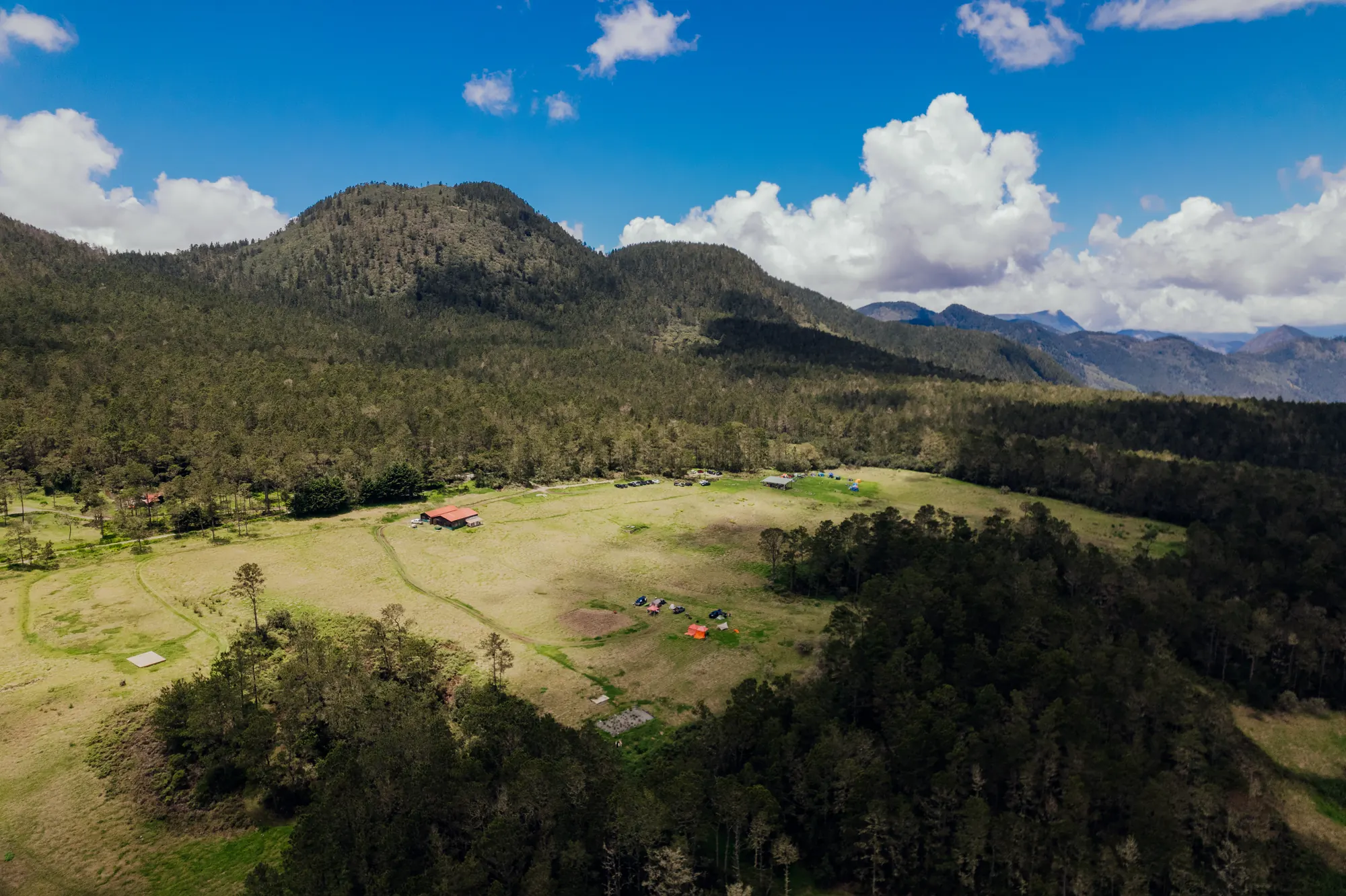 Vista aérea del valle de Villa Pajón, con montañas y nubes